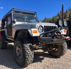 A jeep parked on top of a gravel road.