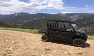 A black utility vehicle parked on top of a hill.