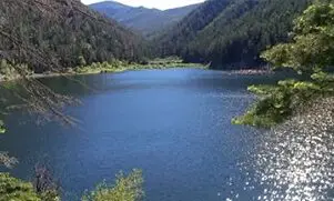 A lake surrounded by mountains and trees.