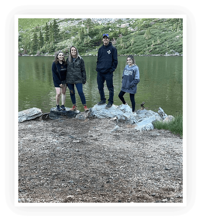A group of people standing on the shore near some trash.